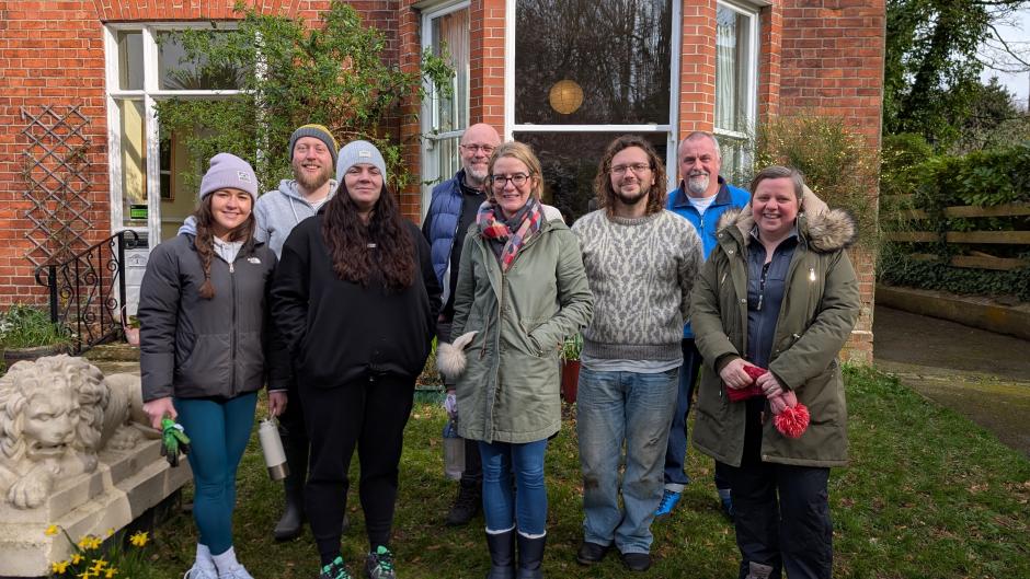 The NIFC secretariat shown in front of the Camphill Community building in their gardening clothes